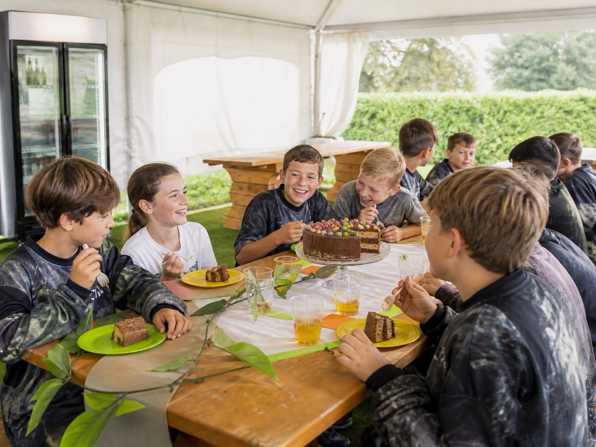 Bambini che mangiano la torta insieme sotto il gazebo